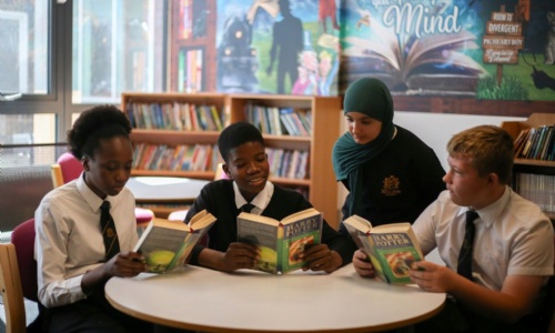 A group of students reading a Harry Potter book